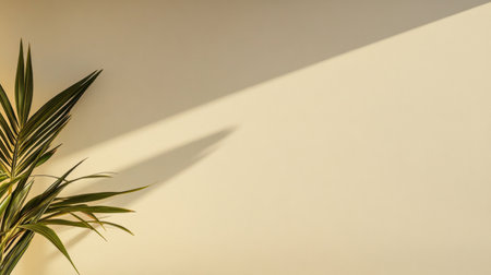 A tropical green plant leans gracefully against a light-colored wall, casting a long shadow that highlights the warm tones of the space, creating a serene atmosphere filled with natural light.の素材