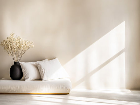 A serene, minimalist space showcases a simple white cushion and a vase filled with dried flowers. Soft natural light creates a calming atmosphere, highlighting the understated elegance of the decor.の素材