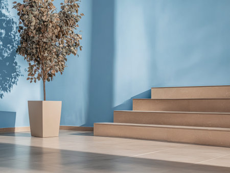 A light-filled interior showcases beige stone steps leading up to a wall painted in soft blue. A minimalist planter holds a decorative plant, enhancing the serene atmosphere.の素材