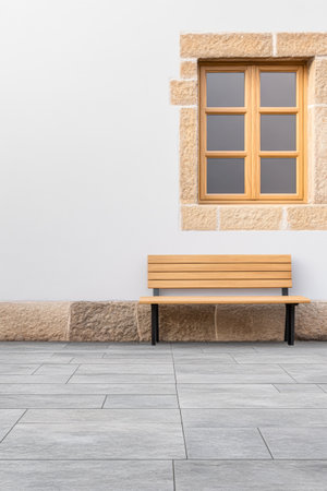 A wooden bench is positioned against a clean, smooth stone wall featuring a rectangular window. The setting exudes a modern yet inviting atmosphere, ideal for relaxation.の素材