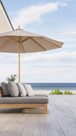 A comfortable outdoor lounge area features a large sunshade and plush cushions, offering a perfect spot to relax while enjoying a view of the tranquil ocean on a sunny day.の素材