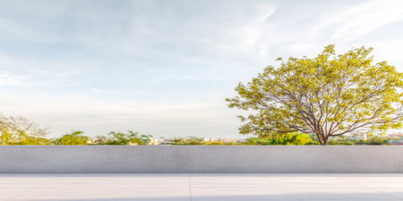 A vibrant scene features a lush green tree standing tall against a clear sky. The backdrop reveals a spacious landscape filled with greenery, creating a peaceful atmosphere.の素材