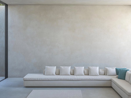 A spacious minimalist living room showcases a large, low-profile white sofa adorned with several cushions.の素材