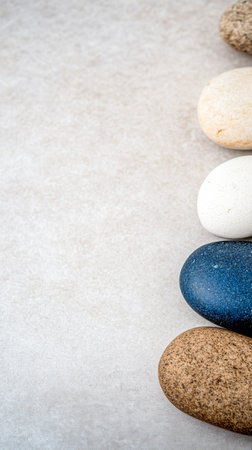 A selection of natural stones lies on a smooth surface, highlighting an array of colors and textures. The stones are organized neatly, offering a tranquil, aesthetic appeal.の素材