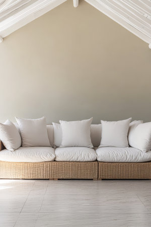 A spacious wicker sofa with plush white cushions is positioned in a minimalist living room. The soft textures complement the light-colored walls creating a welcoming atmosphere.の素材