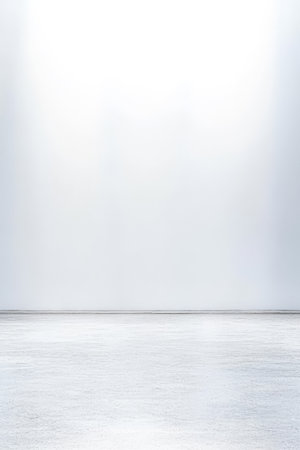 A spacious room features a smooth concrete floor and bright even lighting. The walls are plain and white creating a minimalist and airy atmosphere ideal for various uses.の素材