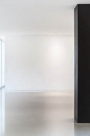 A spacious interior features a stark contrast between white walls and a dark vertical column. The polished floor reflects the light in the minimalist setting creating an airy environment.の素材