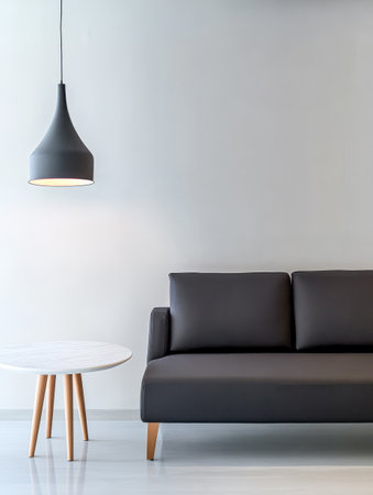 A contemporary living room showcases a sleek black sofa paired with a round wooden side table. A hanging light fixture adds warmth to the minimalist space with gray walls and polished floor.の素材