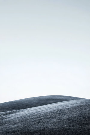 Rolling hills stretch across the landscape bathed in soft light creating a tranquil and peaceful atmosphere. The sky is clear enhancing the gentle curves of the terrain.の素材