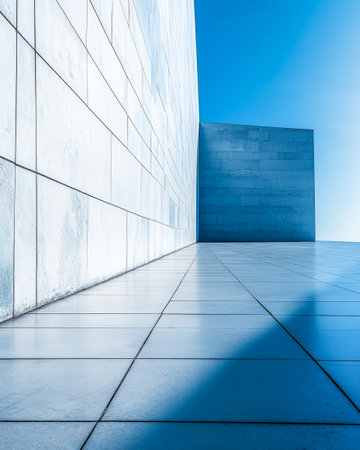A striking example of contemporary architecture showcases smooth surfaces and distinct geometries. The bright blue sky adds to the minimalistic aesthetic enhancing the visual impact of the structure.の素材