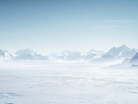 Endless white snow blankets the ground while towering mountains rise majestically against a backdrop of clear blue sky. This serene winter landscape evokes a sense of tranquility and isolation.の素材