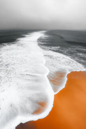 Continuous waves roll onto a unique shoreline where the sand displays a striking orange hue. Overcast skies set a moody atmosphere enhancing the natural beauty of the scene.の素材
