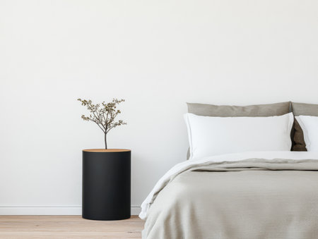 A stylish bedroom showcases a light color palette with a comfortable bed and a minimalist nightstand. A small plant adds a touch of nature to the serene atmosphere in this contemporary space.の素材
