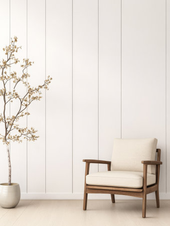 A stylish chair with a wooden frame sits in a minimalist living room. A decorative tree in a pot adds a touch of nature to the simple white walls and light flooring creating a calm atmosphere.の素材