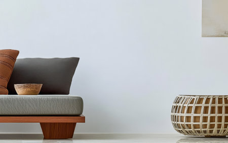 A cozy living room features a minimalist sofa adorned with decorative pillows. A wooden bowl sits on the sofa and a wicker coffee table complements the space enhancing the modern decor feel.の素材
