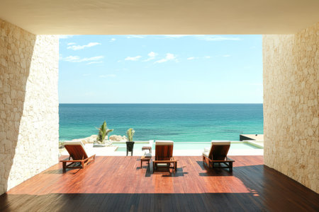 Lounge chairs positioned on a wooden deck provide a perfect view of the tranquil ocean. Calm waves meet a clear blue sky creating a serene atmosphere ideal for relaxation and leisure.の素材