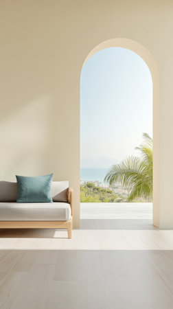 A serene living area features a light-toned couch with a blue cushion framed by an arched window that offers a stunning ocean view and bright natural light illuminating the room.の素材