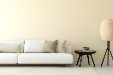 A minimalist living room showcases a comfortable white sofa adorned with two beige pillows. A sleek round table sits next to a unique floor lamp creating a warm atmosphere.の素材