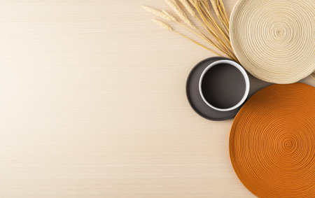 A clean minimalist display features woven placemats in earthy tones along with a simple ceramic bowl and dried grass on a light wood background. This setup emphasizes natural textures and colors.の素材