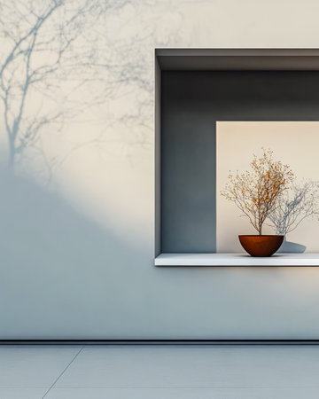 A simple white wall features a rectangular niche displaying a small potted plant. Shadows from branches outside create an alluring pattern on the wall enhancing the tranquil ambiance.の素材