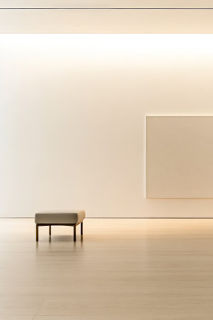 A spacious gallery showcases a simple bench placed on a wooden floor with a blank canvas on the white wall. The design emphasizes minimalism and tranquility inviting contemplation.の素材