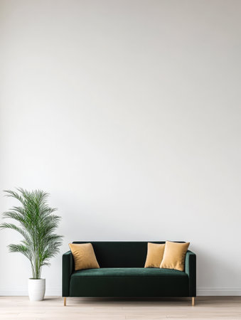 A cozy living room features a dark green sofa adorned with yellow pillows next to a tall potted plant set against a minimalist light-colored wall creating a serene atmosphere.の素材