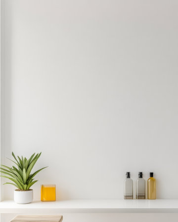 A well-lit space features a simple white wall with a small green plant a glass jar of orange liquid and three bottles arranged on a sleek shelf. The design creates a calming atmosphere.の素材