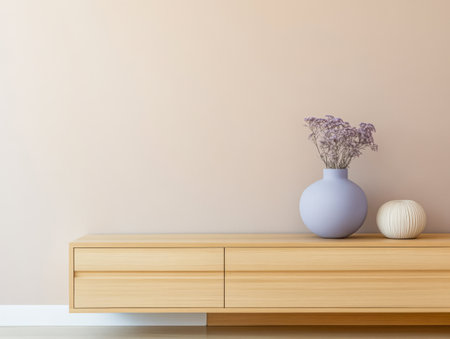 A minimalist living area showcases a wooden sideboard with soft lines and a light lavender vase containing dried flowers. Cozy white textured ball adds warmth to the aesthetic.の素材