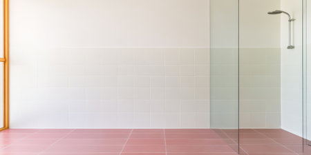 Bright and spacious bathroom featuring pink floor tiles and a large glass shower enclosure. Natural light floods the area from a window enhancing the clean minimalist aesthetic.の素材