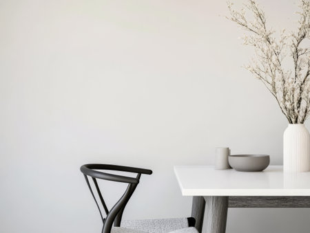 A serene dining space showcases a white table set with a simple vase dish and cup. A stylish chair complements the modern decor creating a calm atmosphere perfect for meals.の素材