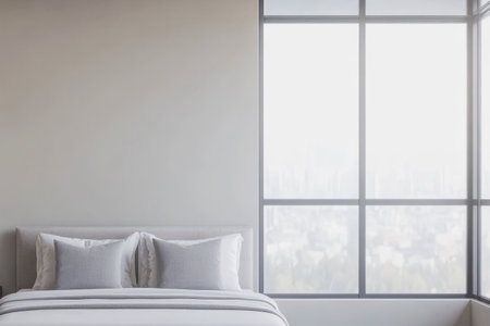 A bright bedroom features a cozy bed with grey pillows minimalist decor and a large window letting in abundant natural light. The view outside shows a blurred cityscape enhancing tranquility.の素材