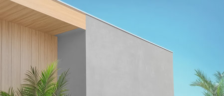 A contemporary building features a sleek gray wall and wooden elements under a bright blue sky. Tropical plants add a touch of greenery to the setting creating a serene atmosphere.の素材