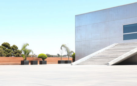 A contemporary structure with stainless steel walls sits alongside landscaped planters. Lush plants frame the entrance while clear skies enhance the bright atmosphere of the space.の素材