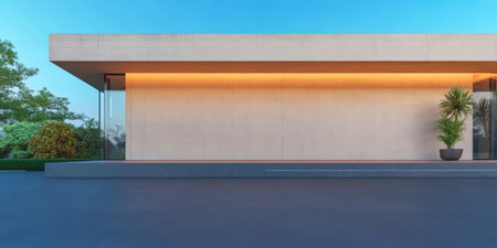 A contemporary minimalist structure stands against a clear sky illuminated by soft lighting. Lush greenery surrounds the building enhancing its elegant design and tranquil atmosphere.の素材