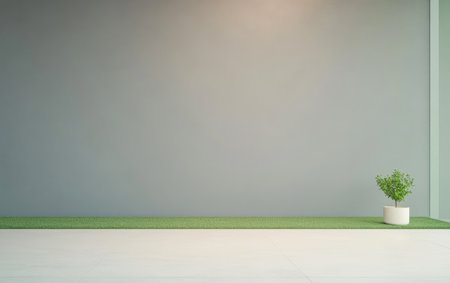 A minimalistic indoor area showcases a smooth gray wall and light flooring complemented by a small plant in a pot on grassy flooring providing a calming and stylish atmosphere.の素材