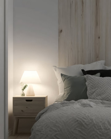 A calming bedroom features soft bedding in neutral tones with decorative pillows stacked on a plush bed. A stylish nightstand holds a warm lamp enhancing the serene ambiance.の素材