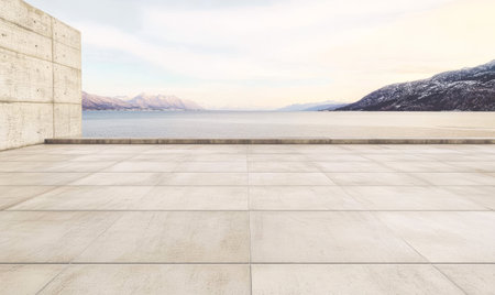 A modern concrete terrace offers a stunning view of a calm waterfront during dawn. Majestic mountains rise in the distance framed by a clear pastel sky reflecting the early light.の素材