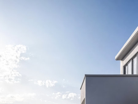 A contemporary building sits beneath a bright blue sky with scattered clouds, highlighting its sleek lines and minimalistic style. The setting captures a calm atmosphere in the daylight.の素材