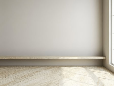 Bright and open interior features a minimalist design, showcasing a light-colored stone floor and a simple shelf by a large window. Natural light floods the area, enhancing the serene atmosphere.の素材