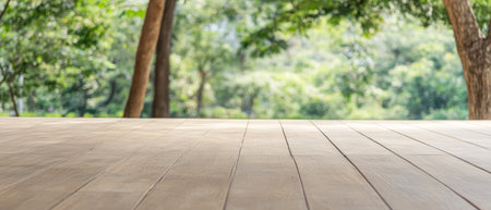 A spacious wooden deck under a canopy of trees showcases vibrant green foliage. Sunlight filters through leaves, creating a serene atmosphere perfect for relaxation or gatherings.の素材
