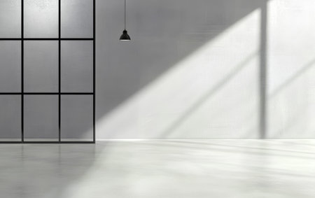 A spacious room showcases clean lines and minimalist decor. A large black frame structure contrasts with smooth white walls, while sunlight casts long shadows on the floor.の素材