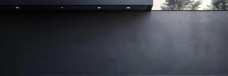 A modern concrete wall stands prominently under a darkened sky during twilight. Soft lights enhance the minimalist design, surrounded by subtle greenery, creating a calm atmosphere.の素材