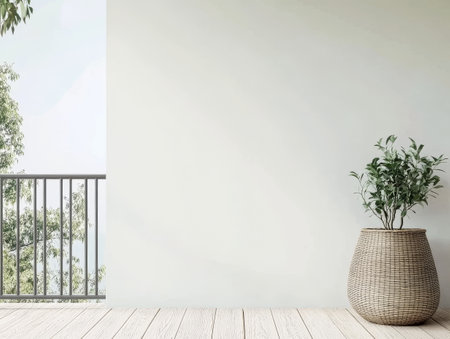 A bright indoor space showcasing a minimalist design with a large empty wall, wooden flooring, and a decorative plant in a woven basket. Natural light enhances the serene atmosphere.の素材