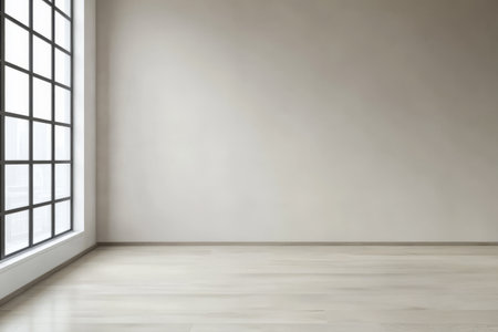 A spacious, empty room featuring a large window that allows natural light to pour in. The walls are painted in a soft hue, and the floor is crafted from light wood.の素材