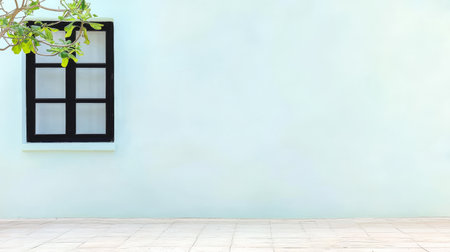 A serene outdoor space features a bright blue wall and a classic black window. The tiled floor complements the minimalist architecture, creating a peaceful atmosphere.の素材