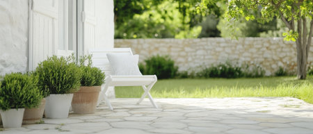A tranquil garden features a white bench and decorative pots filled with plants. The stone patio is bathed in sunlight, surrounded by vibrant foliage and a rustic stone wall.の素材
