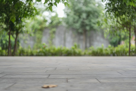 A peaceful garden pathway stretches ahead, flanked by lush greenery and trees. The paved surface invites visitors to explore this tranquil park filled with natural beauty.の素材