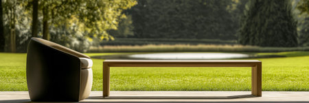 A modern chair and wooden bench sit on a patio, showcasing a serene view of a pond surrounded by lush greenery on a bright day. The peaceful atmosphere invites relaxation.の素材