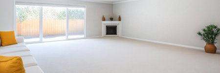 Bright and airy living space with large windows allowing ample sunlight. Soft beige walls and carpet create a calming atmosphere complemented by a stylish fireplace.の素材