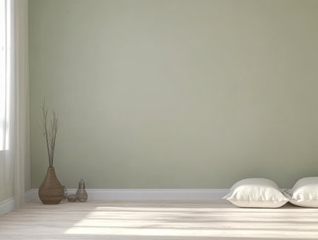 A serene indoor space features two soft pillows on a wooden floor complemented by a vase with dried flowers. Natural light floods the area enhancing the calm atmosphere.の素材